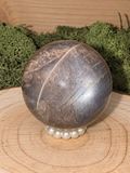 A grade Black Moonstone and lattice Sunstone sphere with silvery asterism, 66g