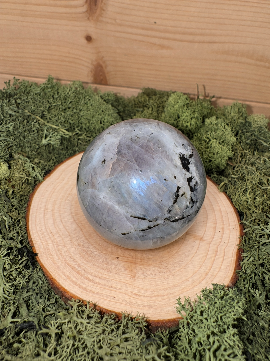 228g polished Labradorite crystal sphere with icy blue flash and natural dark inclusions