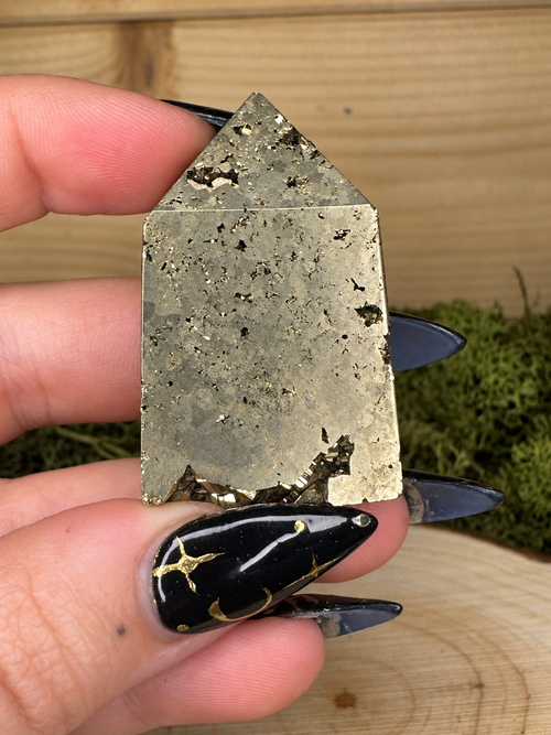 Polished Pyrite tower from Peru showing metallic brass gold colour and natural cavities