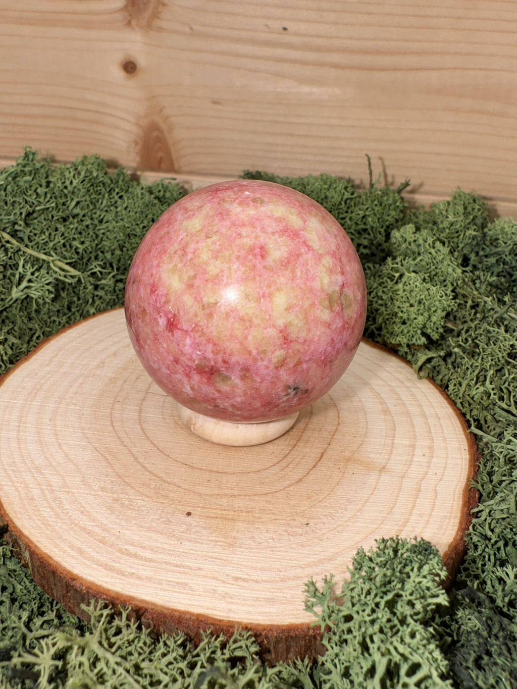 Pink Thulite crystal sphere showing natural raspberry pink cream and green mottled colouring