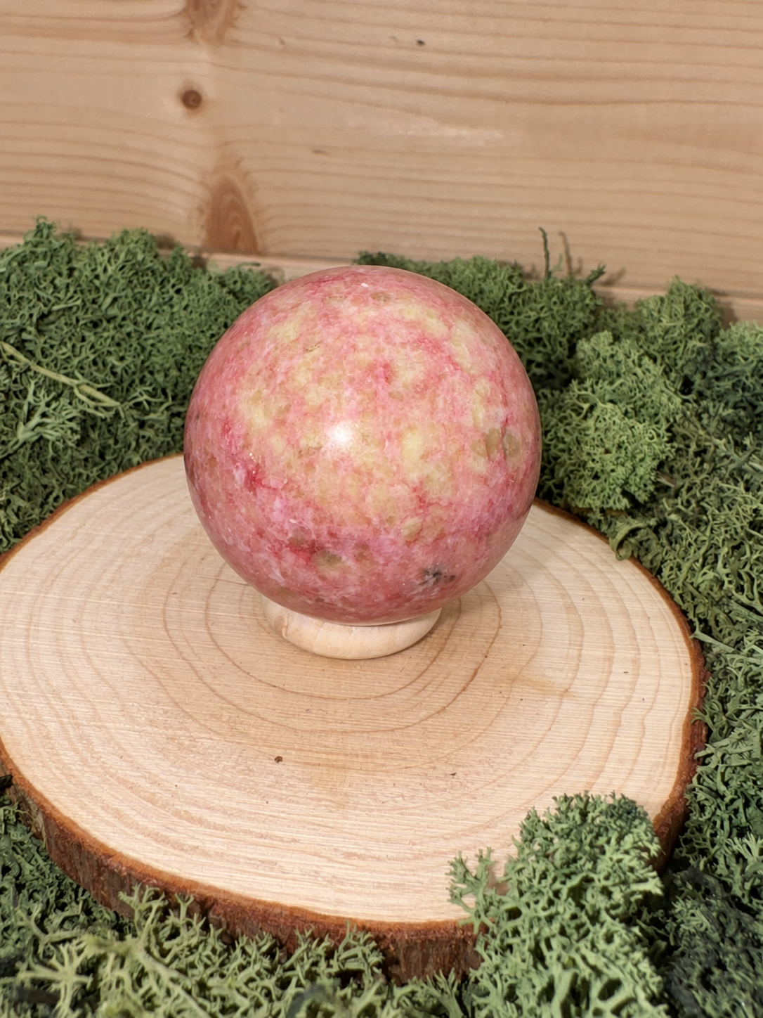 Pink Thulite crystal sphere showing natural raspberry pink cream and green mottled colouring
