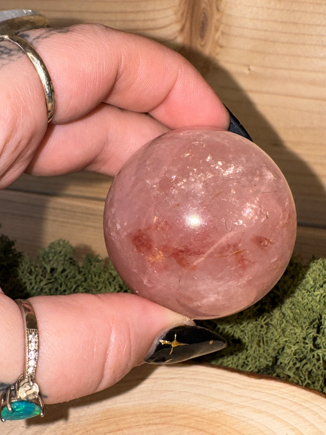 Rose Quartz sphere showing asterism under direct light and Hematite inclusions