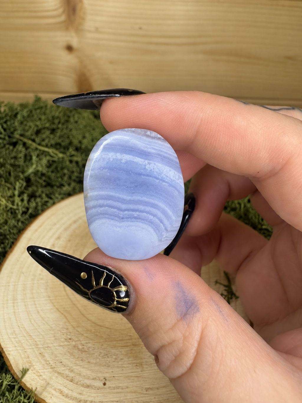 Small Blue Lace Agate flat crystal held in hand showing soft powder blue banding