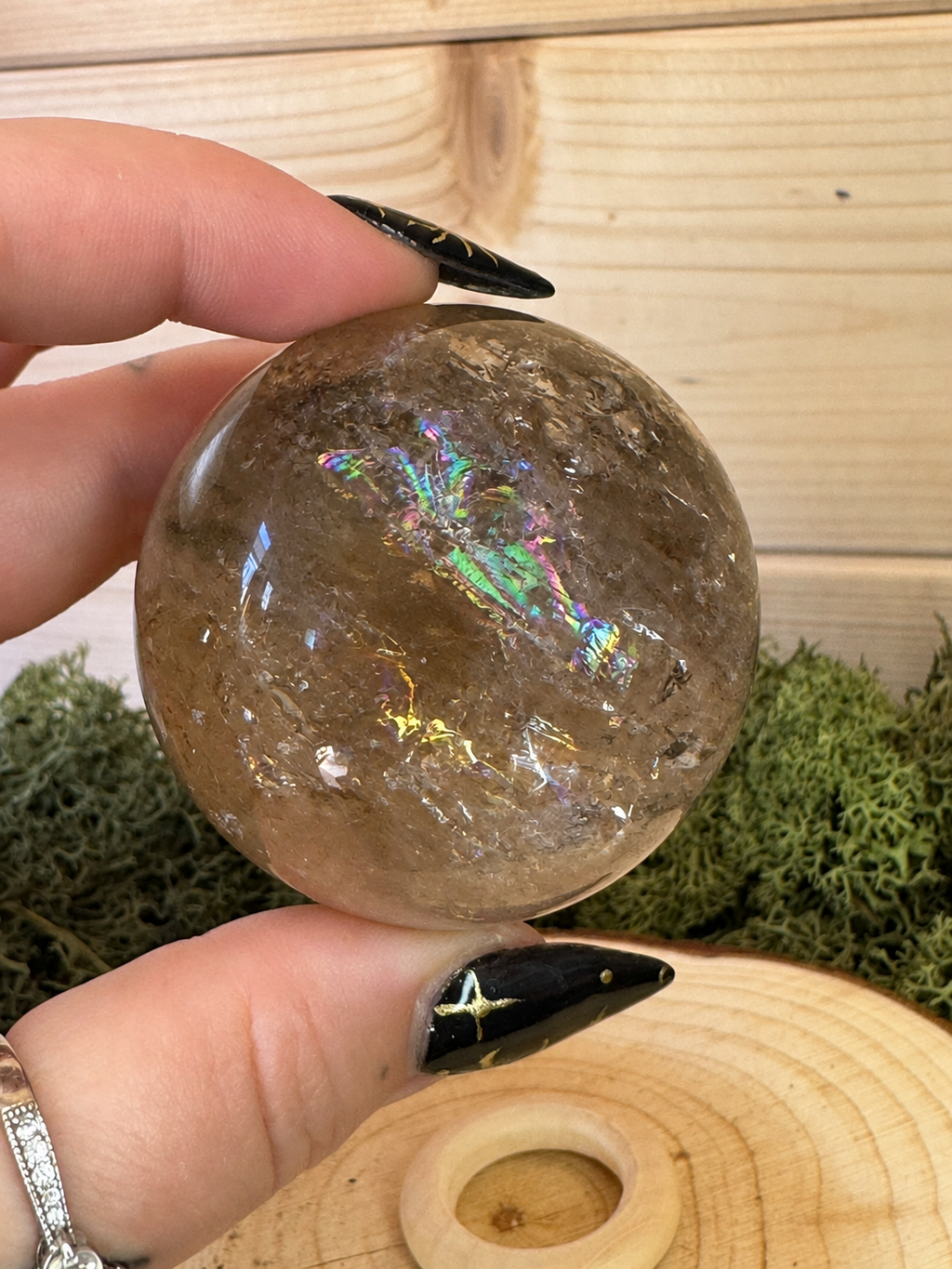 Smoky Quartz crystal sphere showing vivid pink green blue and gold rainbow flashes